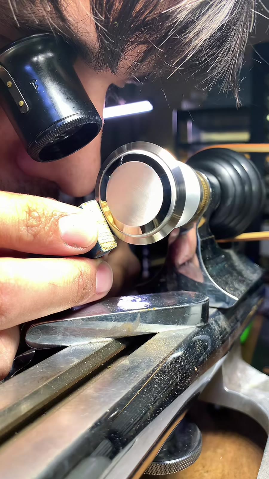 Watchmaker inspecting a part through a loupe